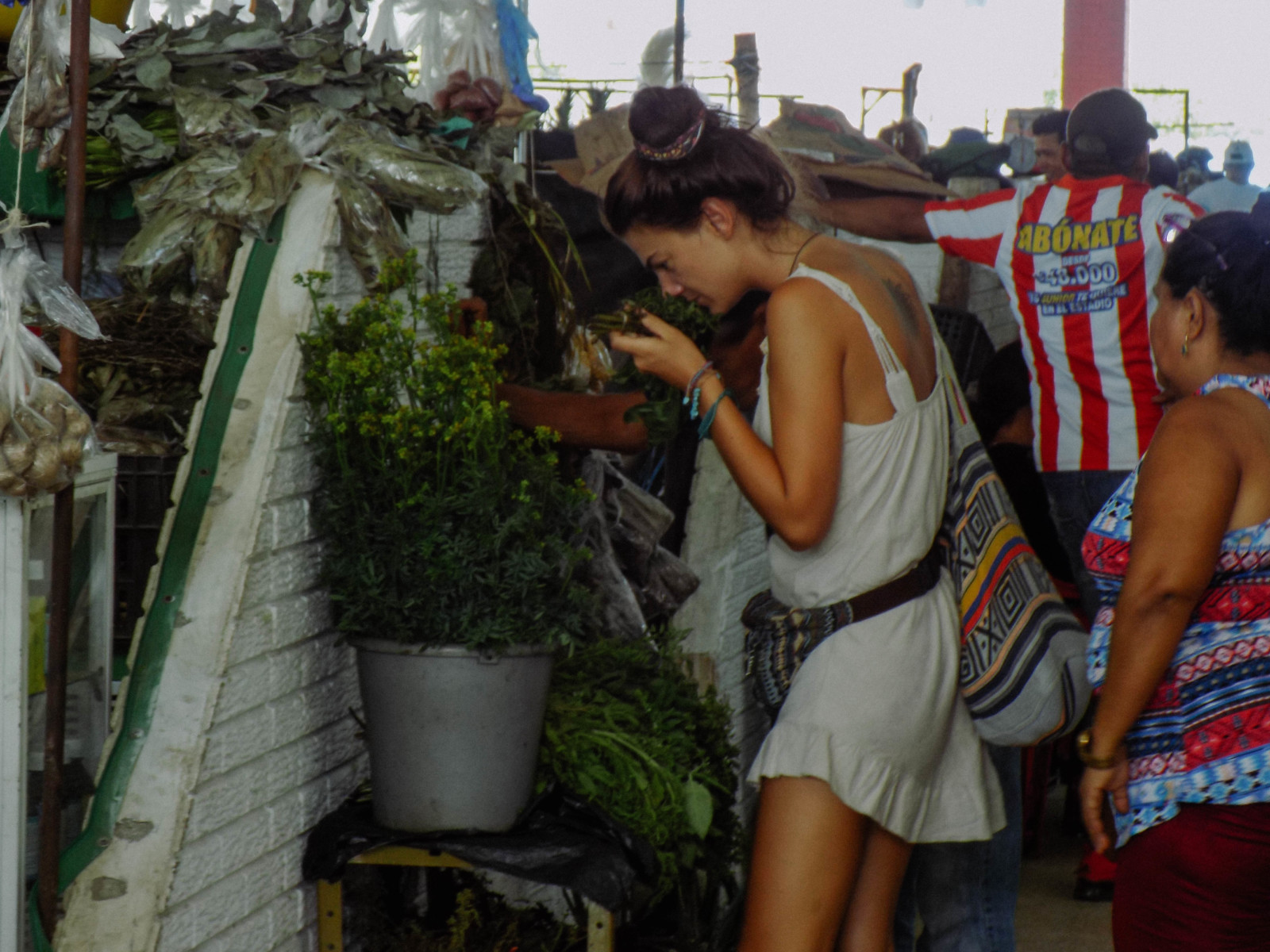 A girl smelling herbs at the market in Santa Marta