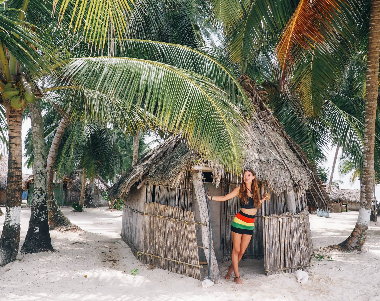 A girl standing in the front of her bungalow on the beach 