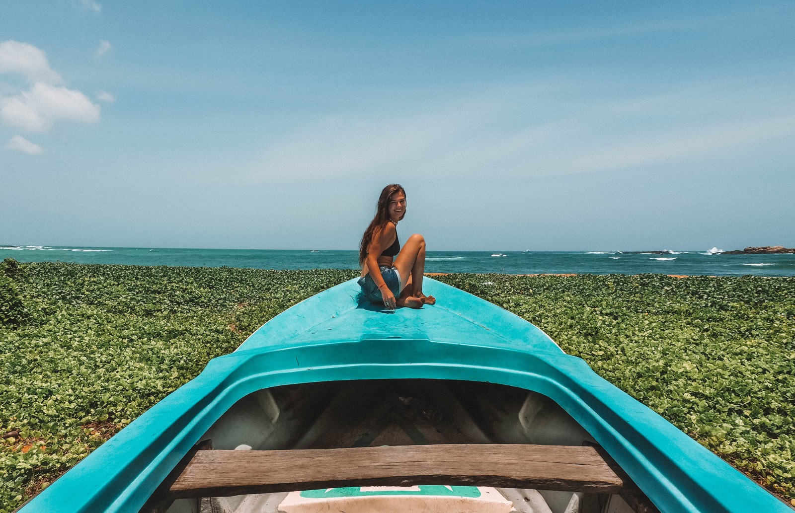 A girl sitting on the boat on the Unawatuna Beach
