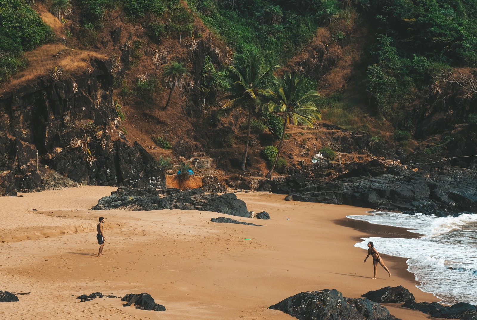 couple playing frisbee on the paradise beach in Gokarna