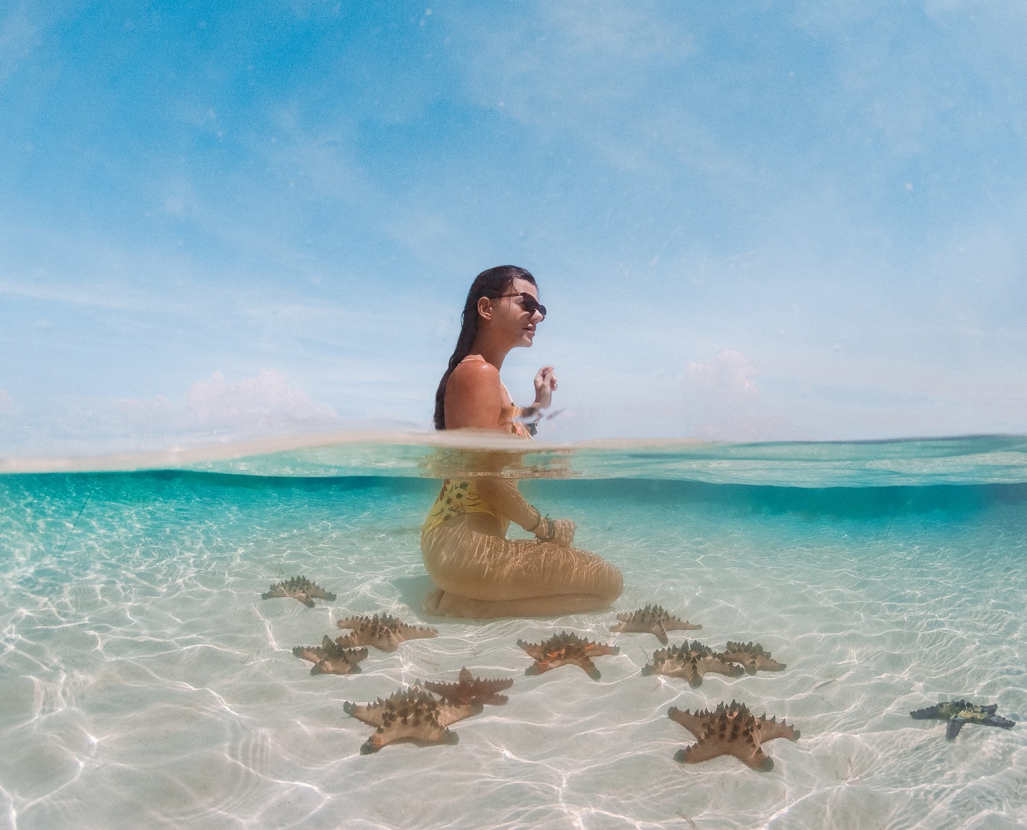 a girl in the ocean with starfish