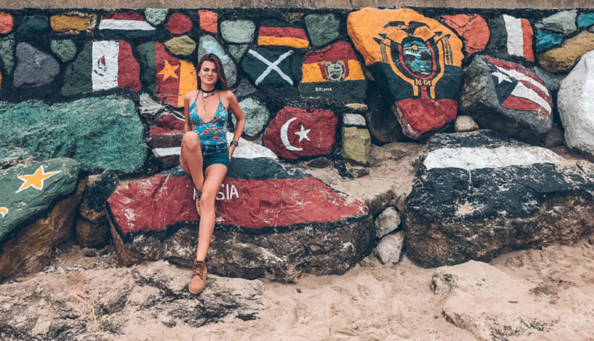 A girl sitting on the colorful rocks painted in maps