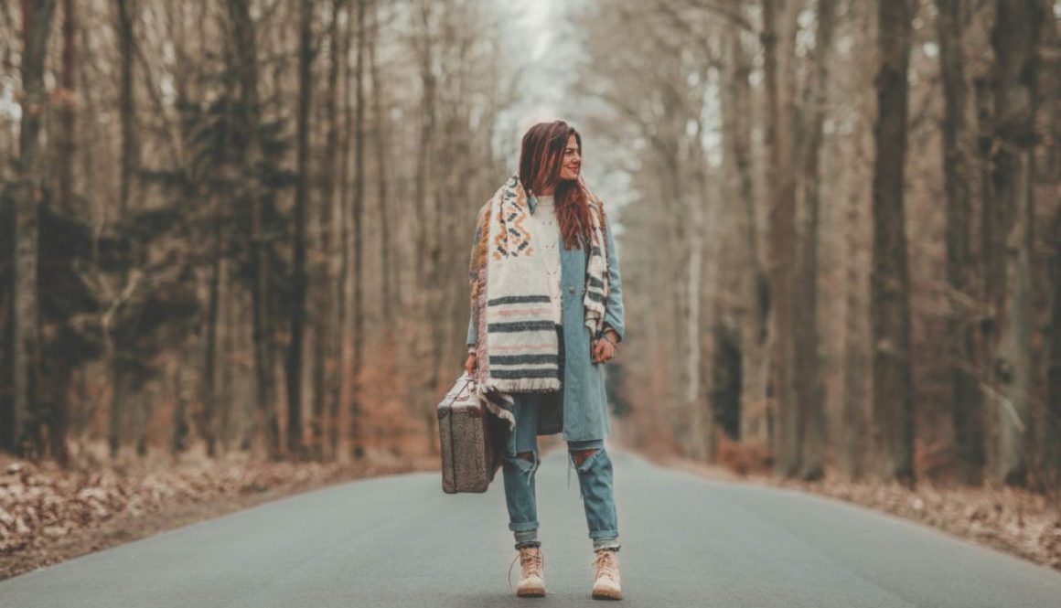 A girl with a luggage on the road