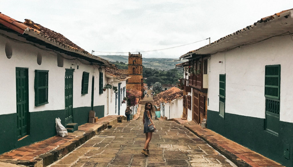 A girl walking on cobblestone street in Barichara