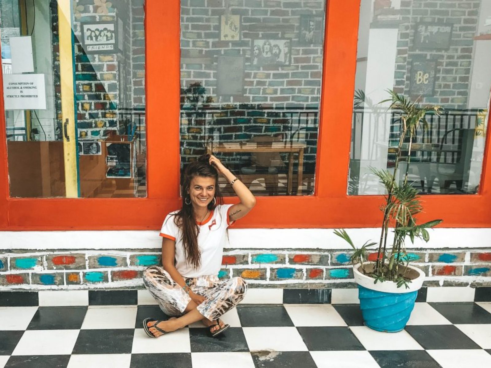 A girl sitting on the floor in the colorful hostel in India
